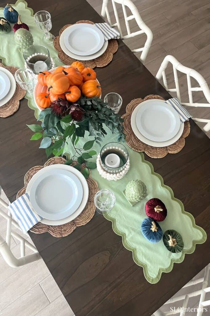 Dining table decorated with fall-themed centerpiece and tableware for autumn celebration.
