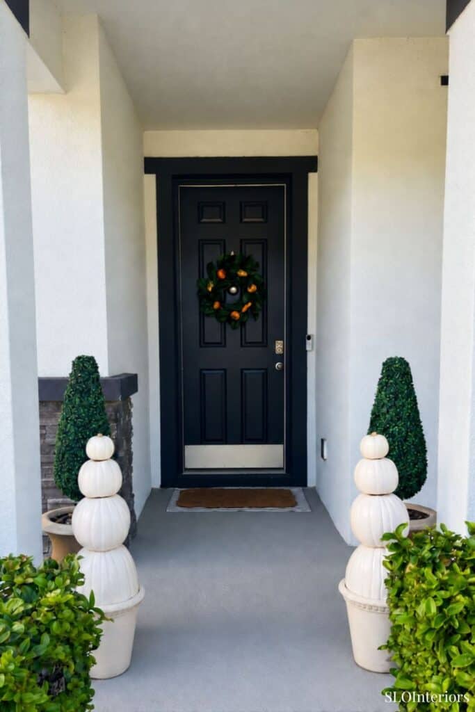 Front door decorated with a holiday wreath and festive planters.