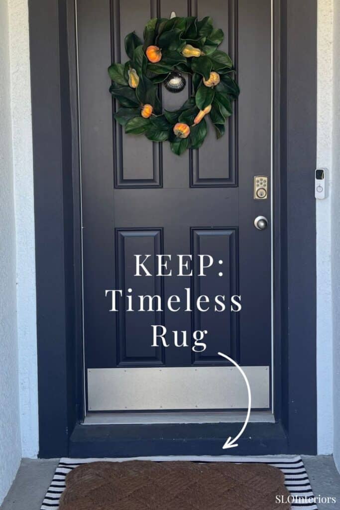 Front door with holiday wreath and timeless rug at entrance.