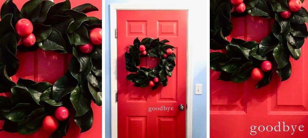 A festive holiday wreath with red ornaments on a red door.
