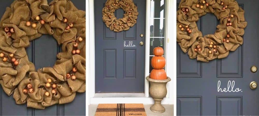 A festive burlap wreath with pinecones and ornaments on a navy blue door.