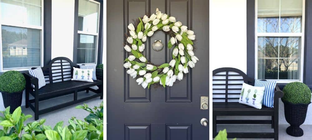 Elegant black porch bench with decorative pillows and greenery in front of windows.