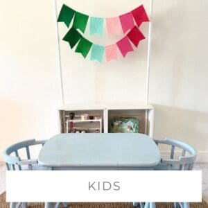 Colorful kids' craft table with decorations and storage in a playroom.
