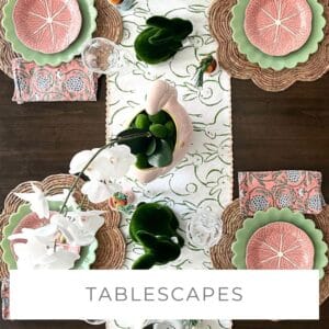 Elegant table setting with pink citrus-themed plates and floral centerpieces.